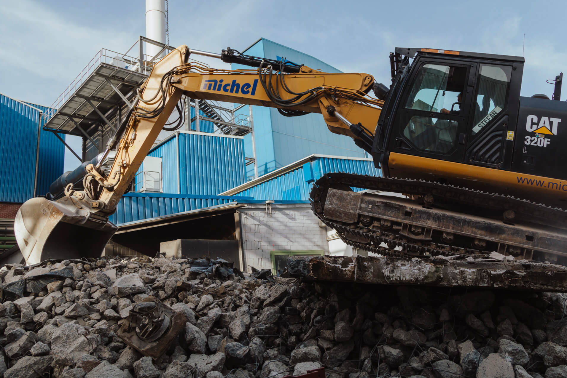 bagger-auf-bauschutt-kette-vorne-in-der-luft-desktop-michel-bau