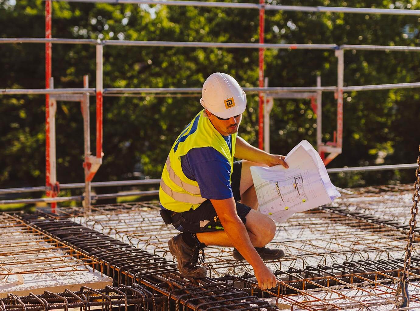 bauarbeiter-mit-plan-auf-stahlbewehrung-hochbau-desktop-michel-bau